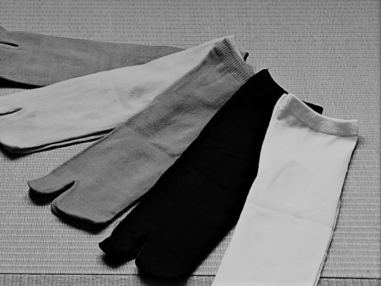畳の上に5足の足袋が並んでいる。白黒写真。