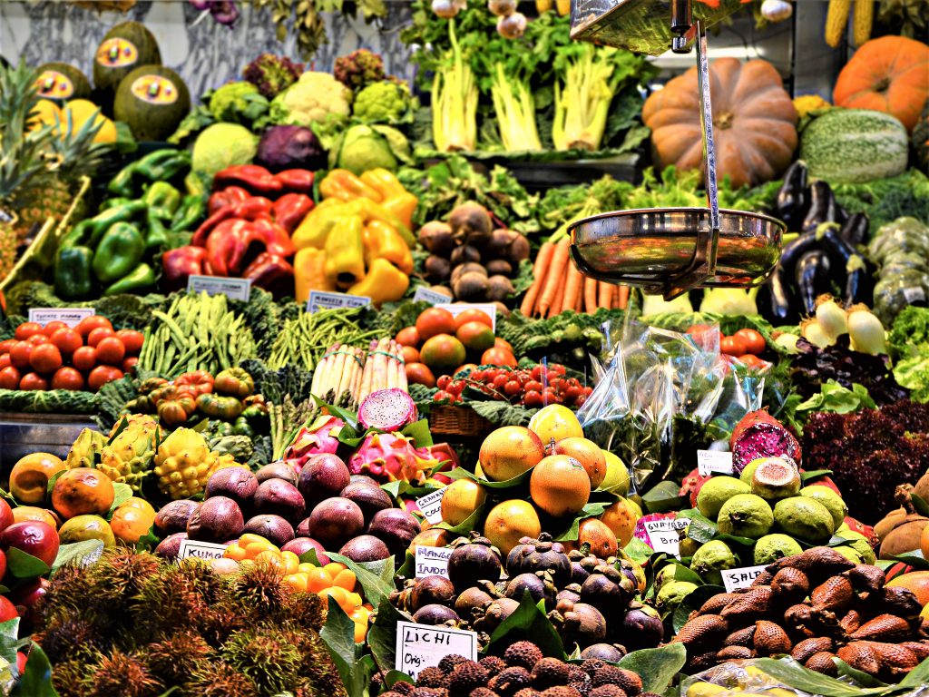 市場、またはスーパーマーケットの青果コーナー。カラフルな野菜や果物が美しく並べられている。
