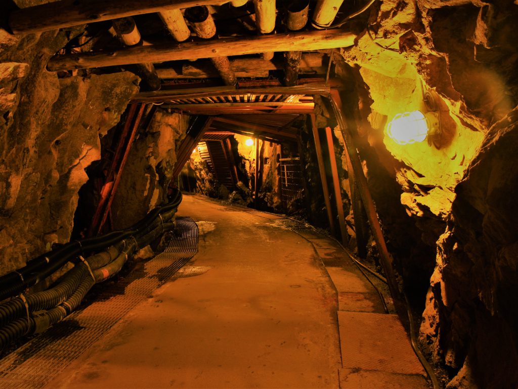 トンネルのような薄暗い穴に明かりがともされている銅山