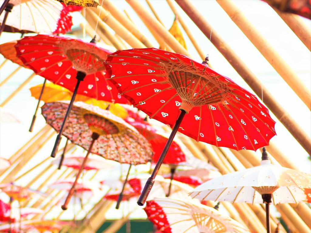 小さめのカラフルな和傘が天井にたくさんつるされている様子。