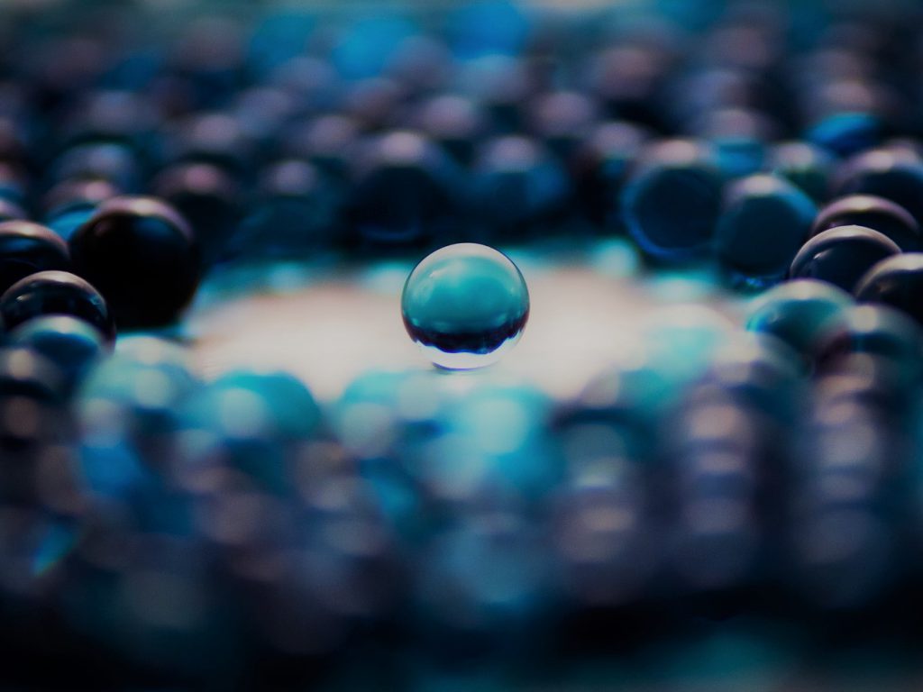 水色っぽい真珠の球が敷き詰められて輪になっているところに一粒だけポツンとある幻想的な画像。
