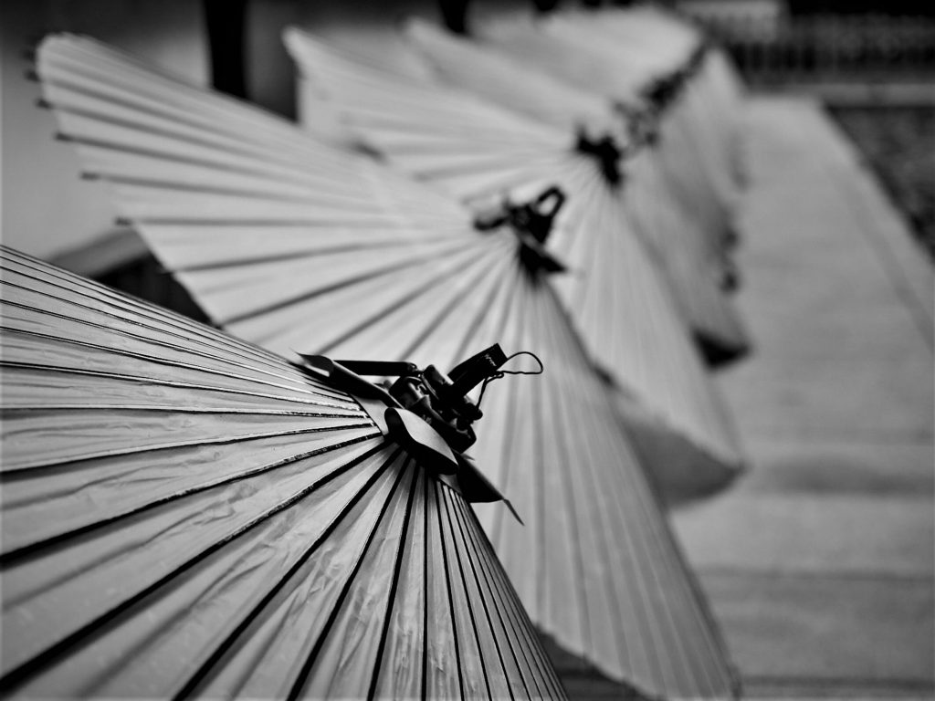 番傘が縦に並んでいる白黒写真。