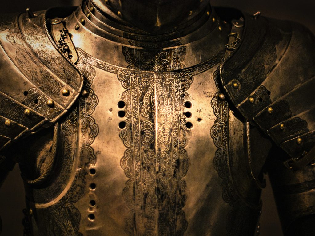 中世の騎士の甲冑が暗がりの中輝いている
