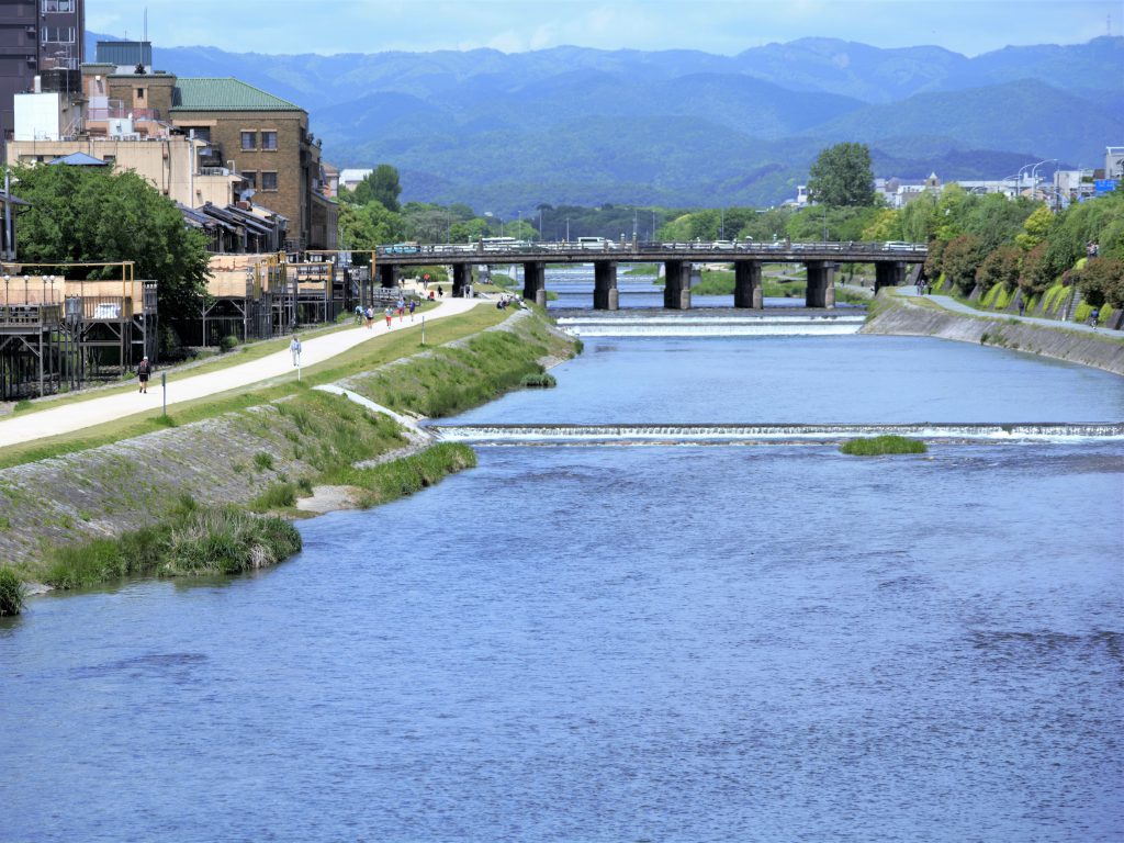 青空の下鴨川の河川敷と箸が見える様子