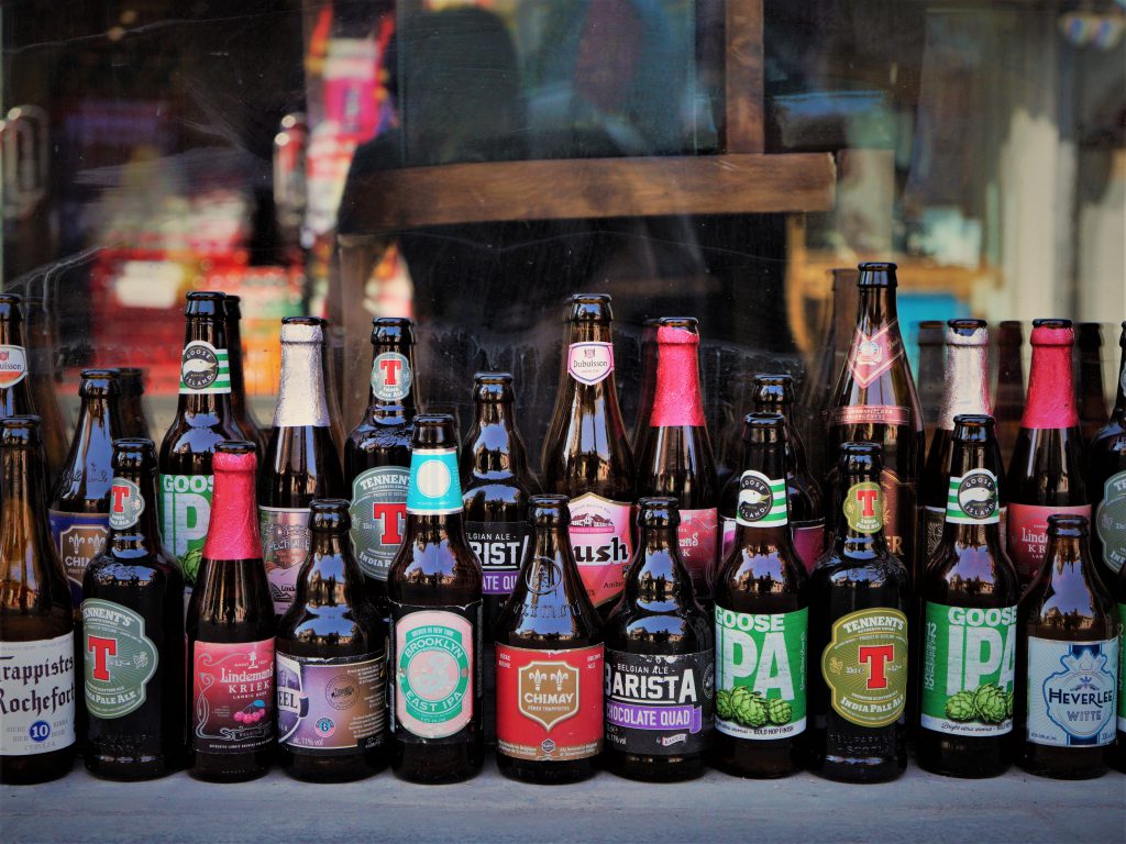 海外の色とりどりのラベルが付いたクラフトビールの瓶がたくさん並んでいる