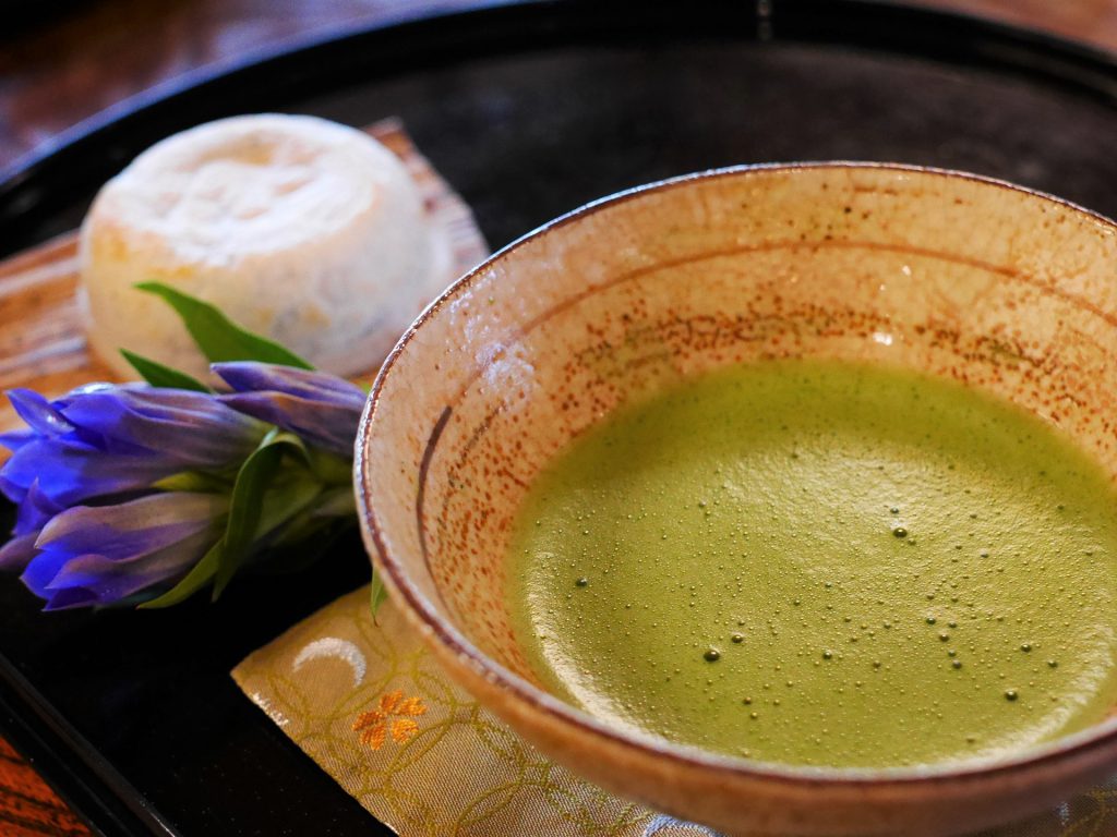 茶碗に入った抹茶と白い和菓子が並んでいる様子