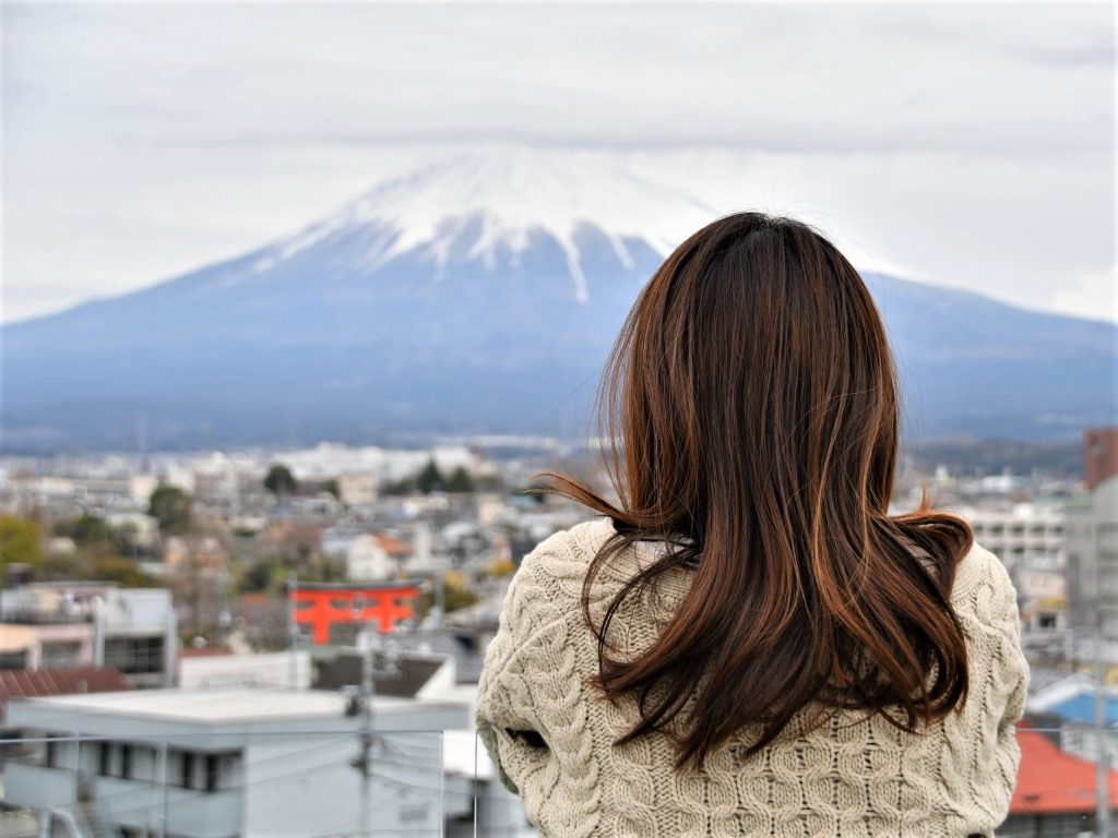 富士山をベランダから眺めるミディアムヘアの女性