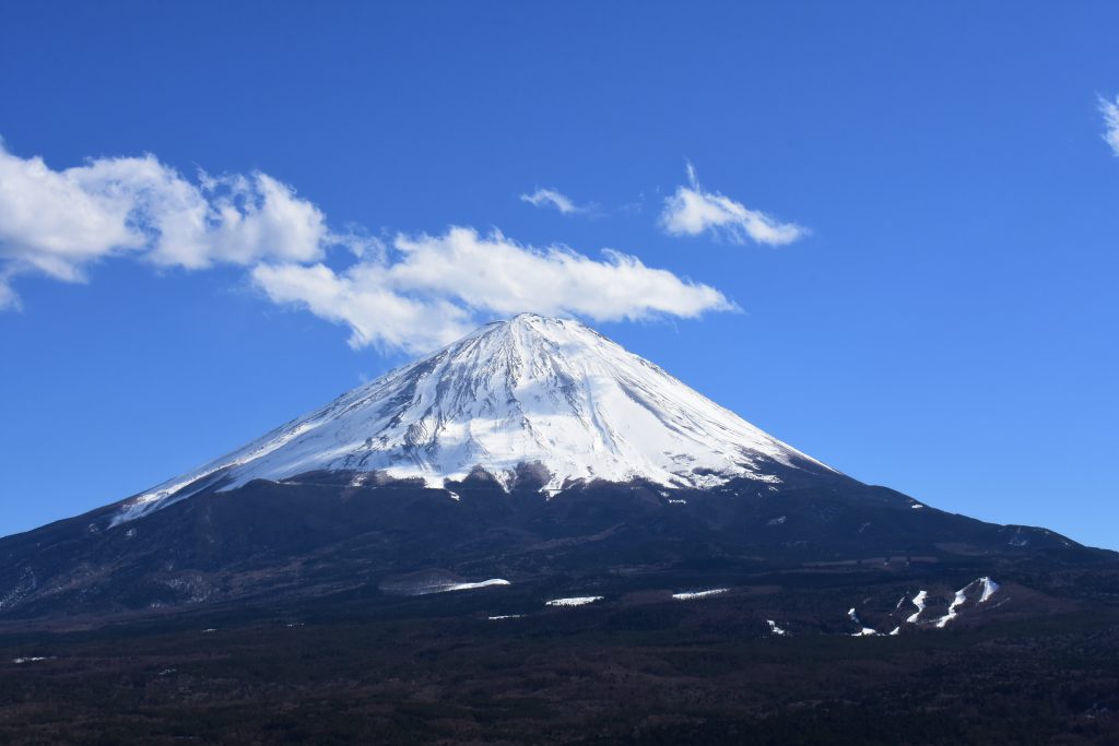 青空と白い雲の中にそびえたつ富士山