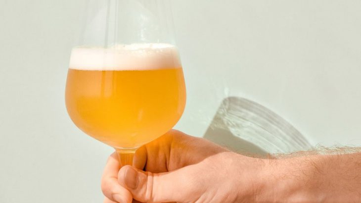 白い壁にグラスに入ったビールが注がれている