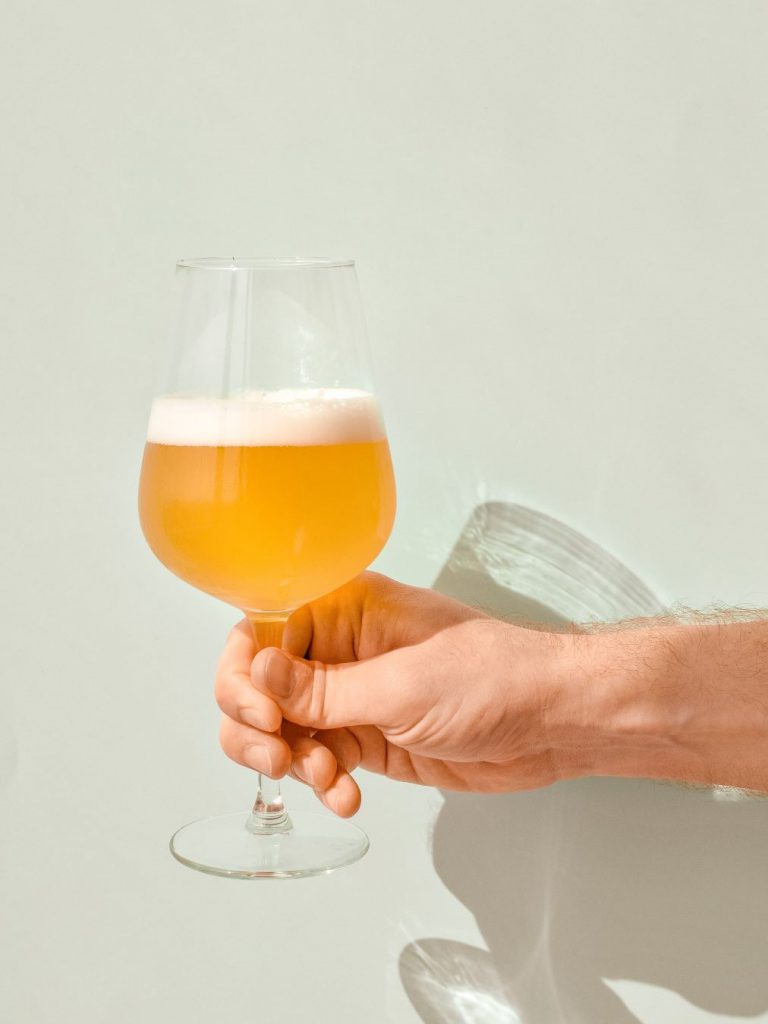 白い壁にグラスに入ったビールが注がれている