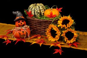 ジャックオランタンとかごに入ったかぼちゃ、ヒマワリで飾りつけられている