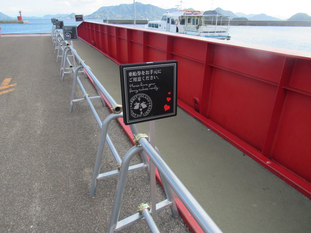 忠海港のフェリー乗り場にある誘導看板の写真。うさぎのイラストが描かれている
