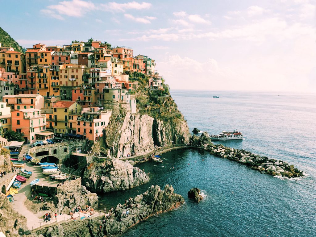 イタリアの風景写真。絶壁の上に色とりどりの家が所せましと並んでいる。