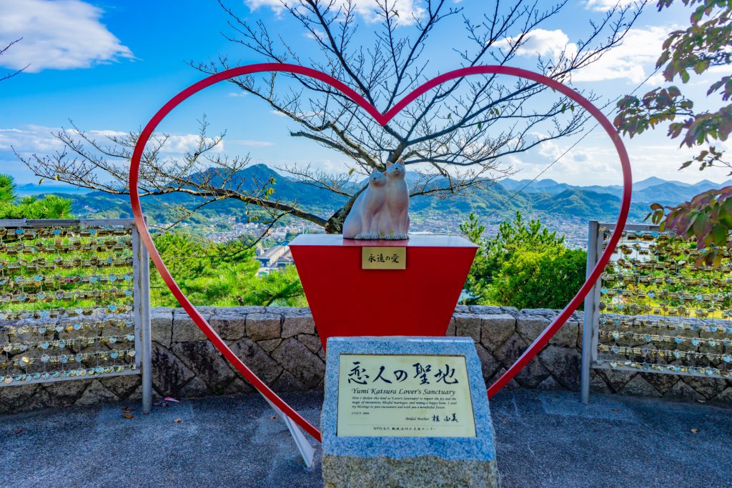 千光寺公園内にある「恋人の聖地」の様子。ハートのモニュメントの真ん中には二匹の猫が寄り添う像がある。