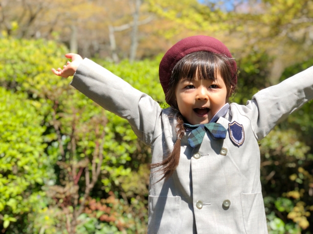 制服でバンザイする幼稚園児