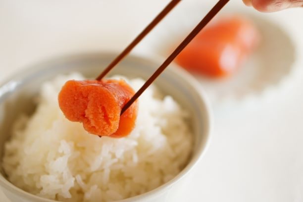 明太子ご飯。明太子を箸でつまんでいる。