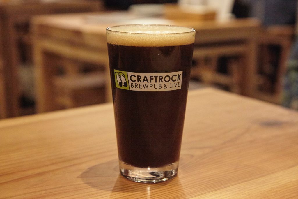 CRAFTROCKの文字の入ったグラスに注がれた黒ビール。箕面ビールのスタウト。