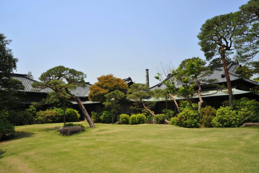 野田市市民会館の様子。庭が青々として美しく、木々が植わっている。