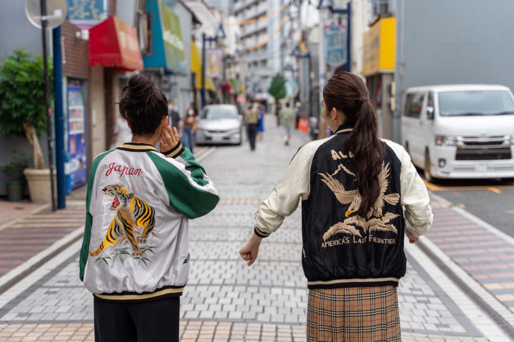 スカジャンを着て横須賀どぶ板通りを歩く女性二人