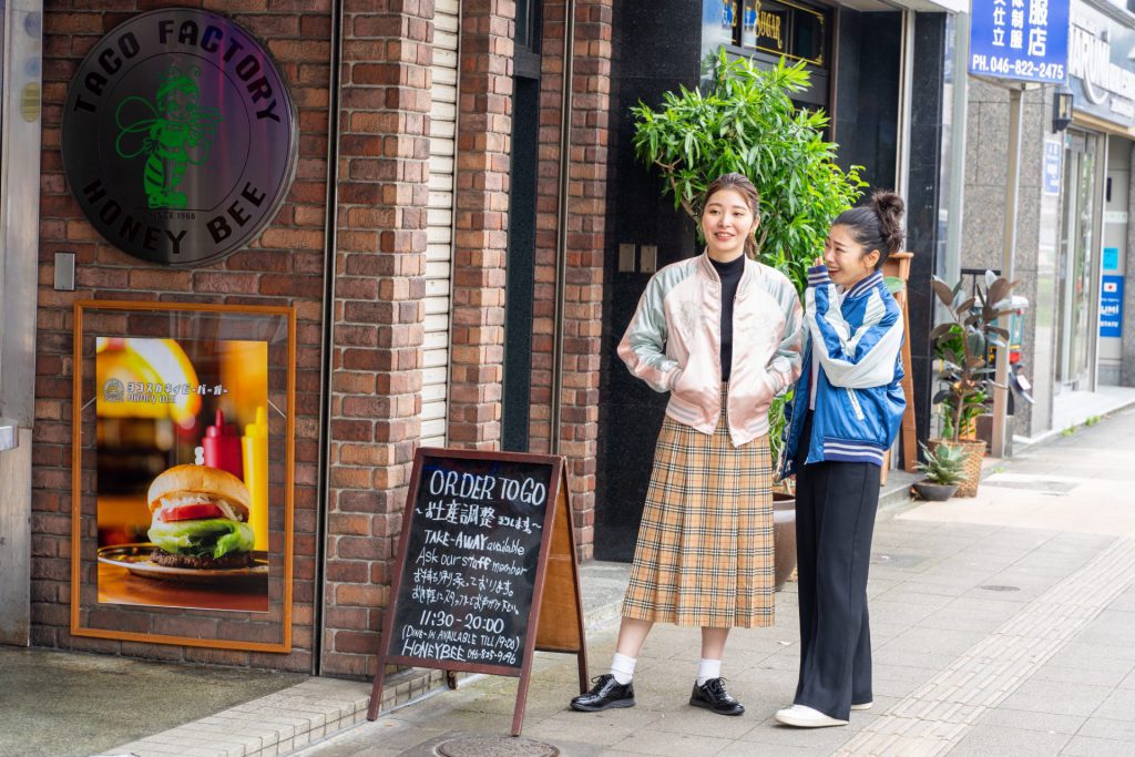 スカジャンを着て横須賀どぶ板ストリートでたたずむ女性二人