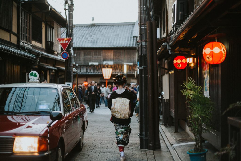 花見小路通。道を歩いている舞妓さんの後姿と京都らしい建物が見えます。