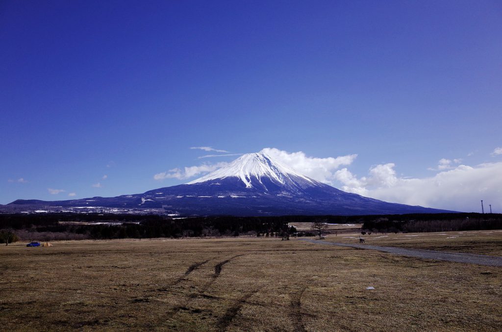 雄大な大地の奥に、雪をかぶった富士山が見えます。