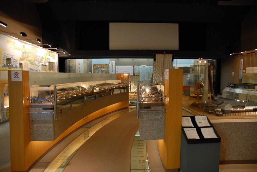 品川歴史館。中央の通路には歴史的資料がケースに入った状態で並べられ、昔の街並みのジオラマや地図も展示されています。