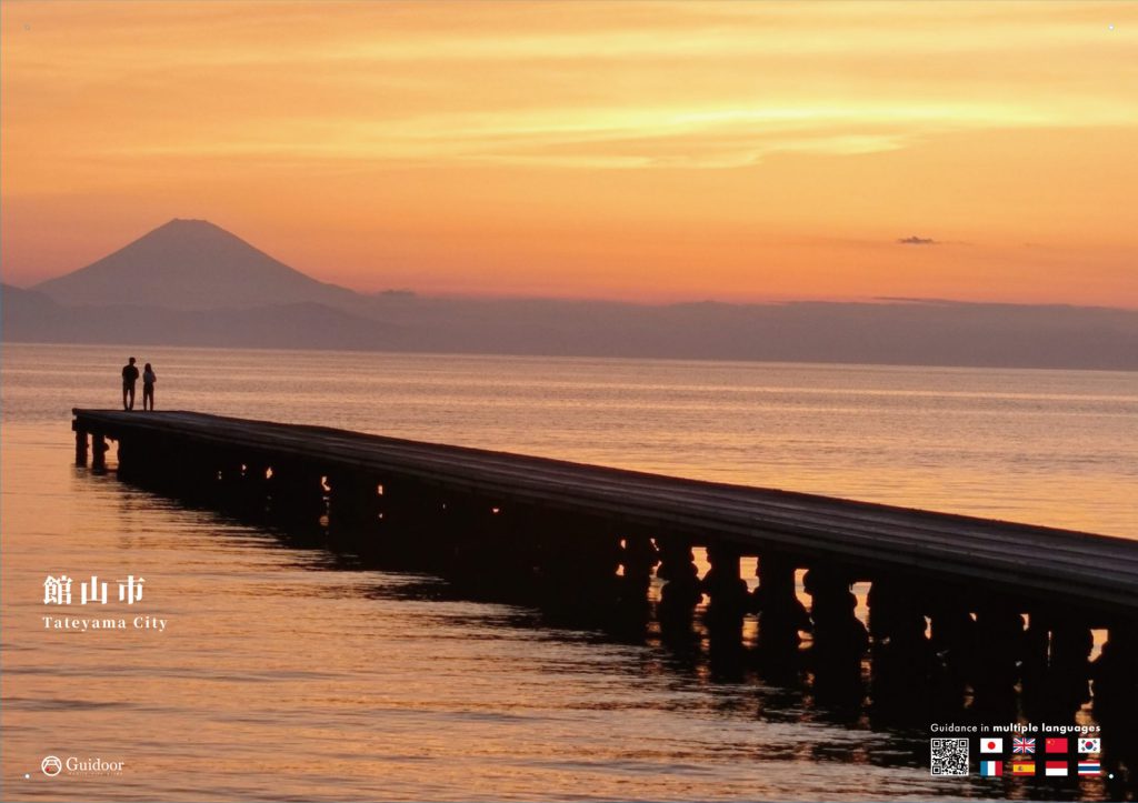 夕焼けの中、館山湾にある館山夕日桟橋の端にいる2人が富士山を見ている様子。