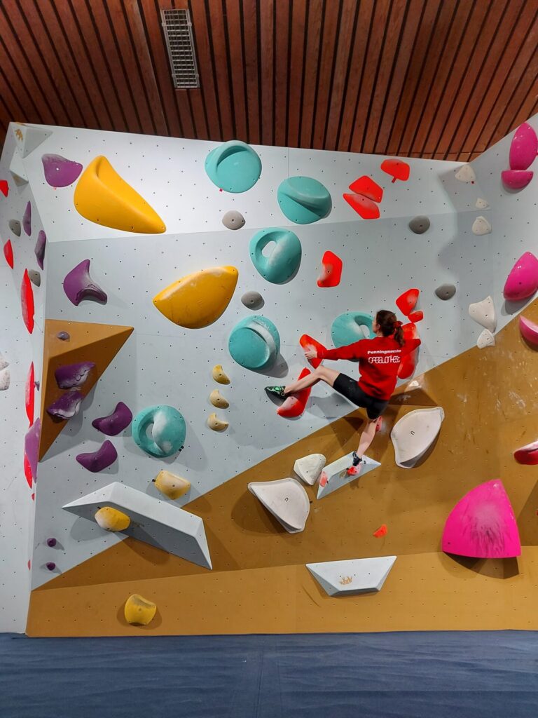 ボルダリングの壁を登っている女性