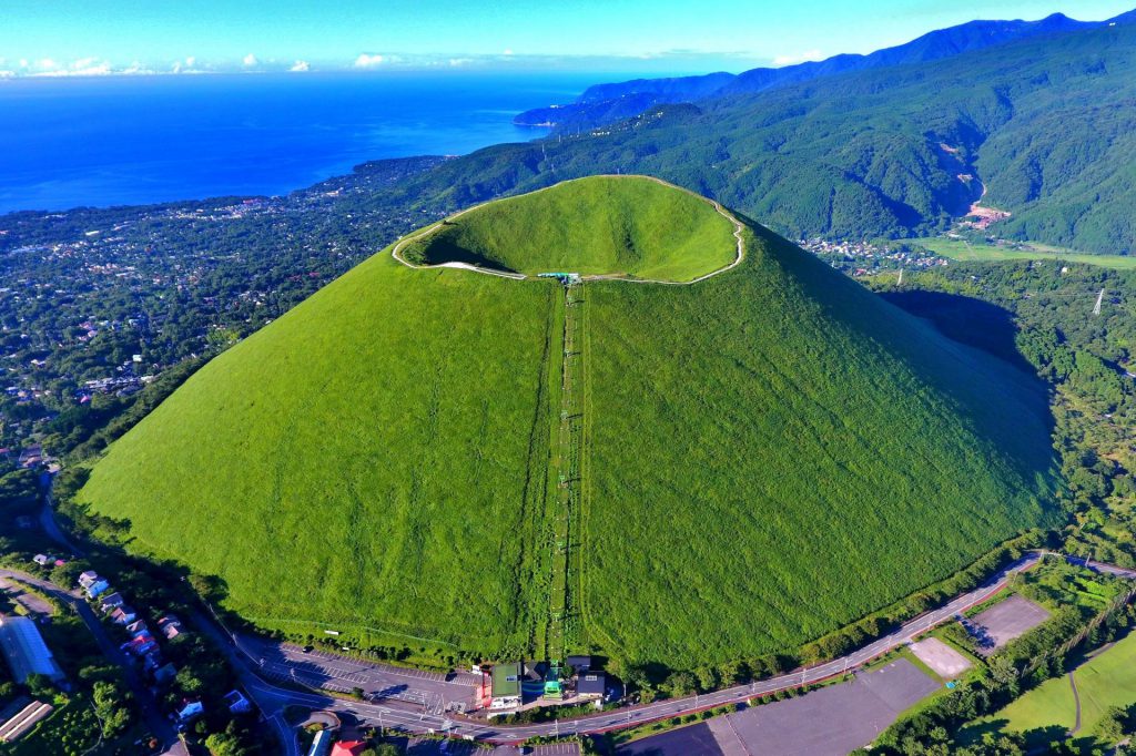 大室山の様子。鮮やかな黄緑色をしており、頂上までのリフトが見える。