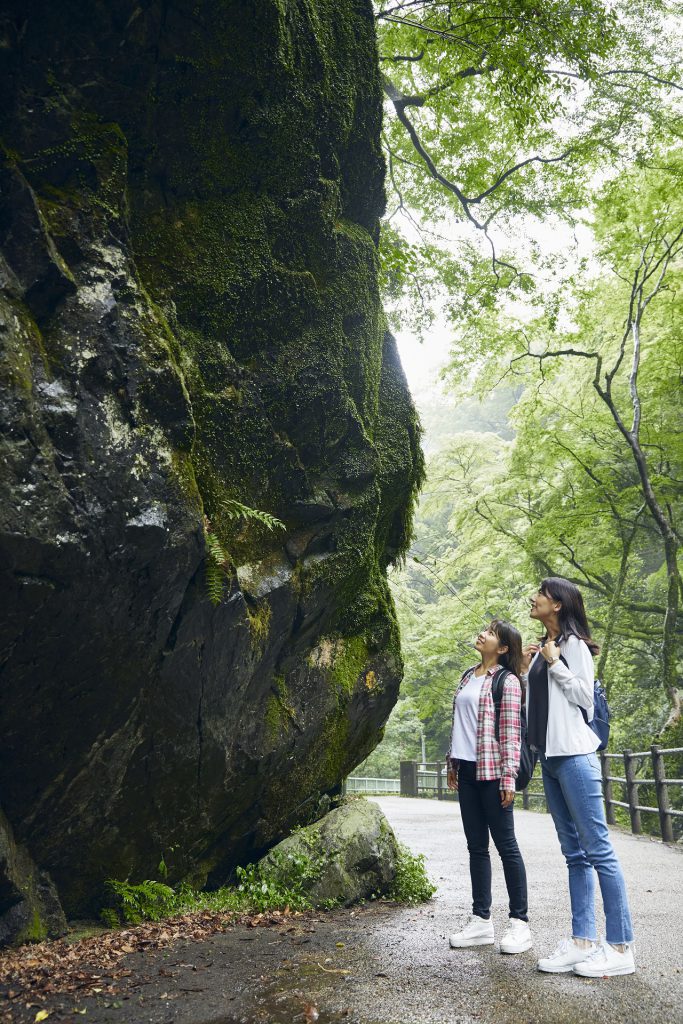 二人の女性が唐人戻岩を見上げている。
