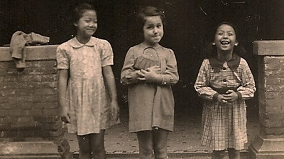 ユダヤ人と中国人の少女たちが笑顔で並んで立っている様子。