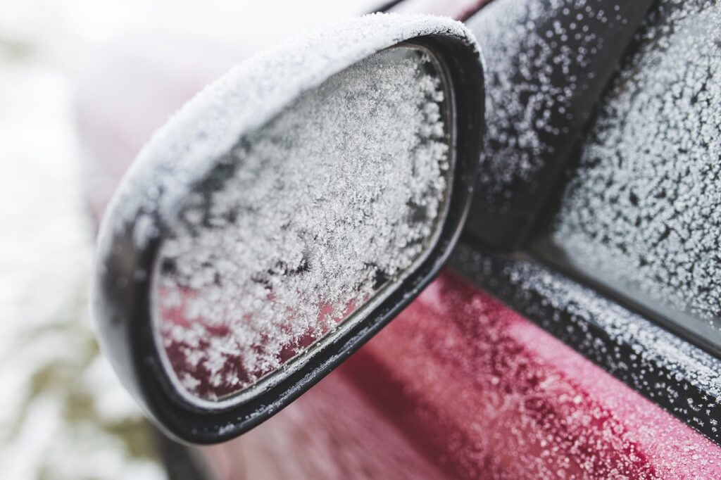霜がついた赤い車のサイドミラー。