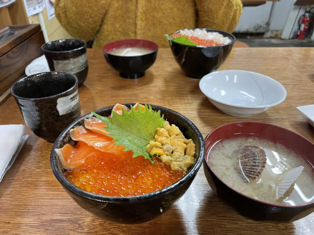 いくら、ウニ、サーモンがふんだんにのった丼。隣には蛤のみそ汁も。