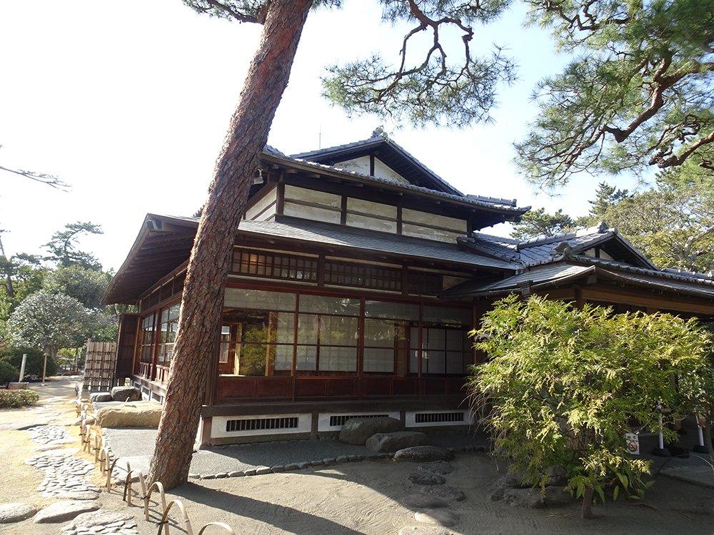 「陸奥宗光別邸跡・旧古河別邸」の外観。庭先の松の木と写っている様子。日本式の木造建築の邸宅。