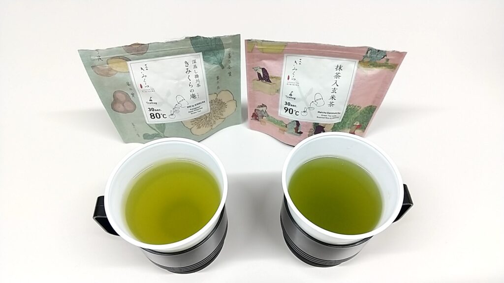 「日本茶きみくら」の商品「Art Print Package (Teabag) Collection」の2種類。左が緑のパッケージの静岡県産掛川茶。右がピンクのパッケージの抹茶入玄米茶。それぞれパッケージが並び、その前に置かれたコップにお茶が入っている。