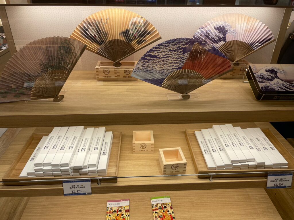 「羽田エアポートガーデン」のショッピングエリアの1つ「TOBI・BITO・SWEETS 」の商品で、富士山の有名な日本画が描かれた扇子などが販売されている。