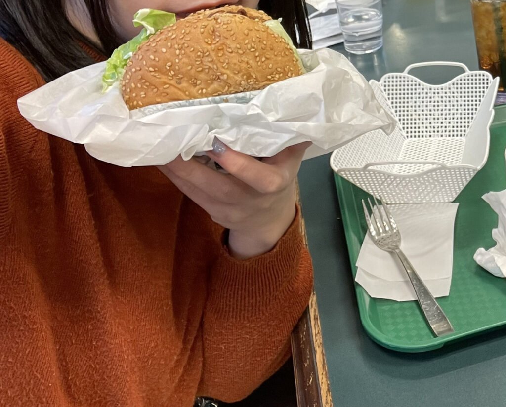美味しそうなハンバーガーを手に持っている写真。