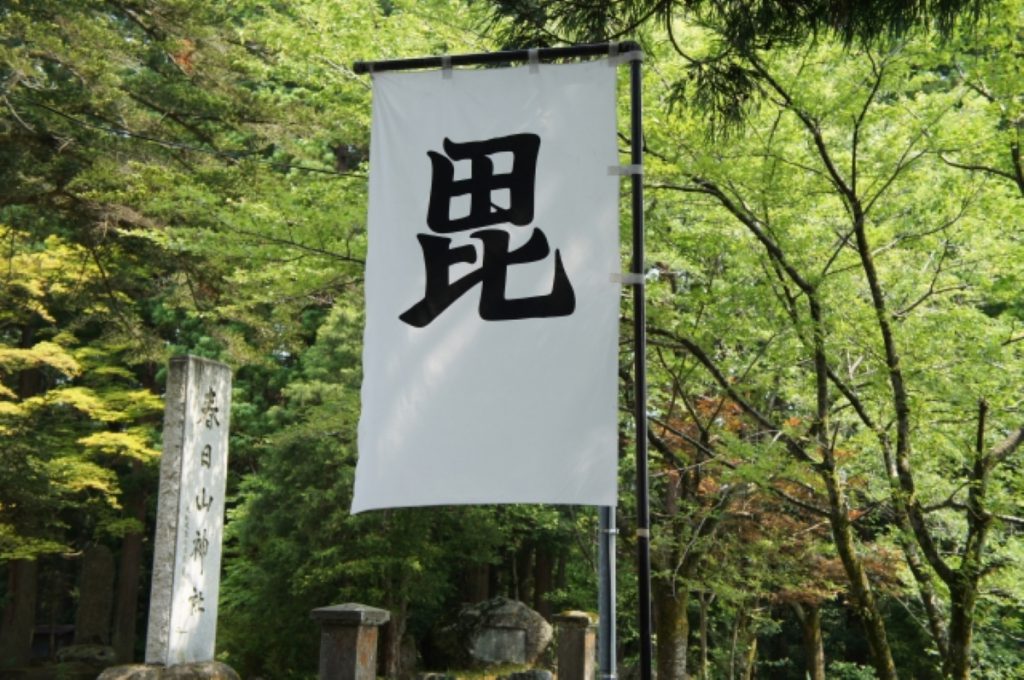 春日山神社に上杉謙信以来、軍旗に使われている「毘」の文字が書かれた旗が立つ様子