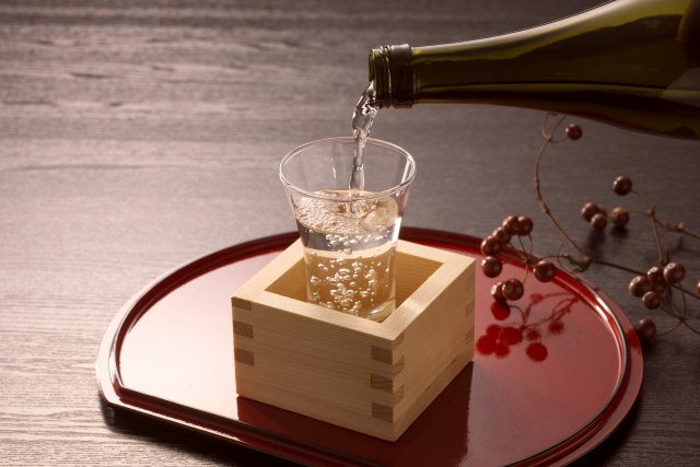 升に入っているグラスに日本酒が注がれている
