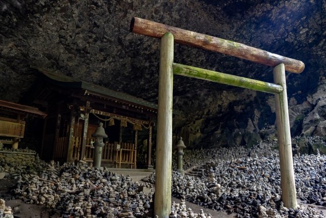 天岩戸神社と鳥居。地面には石が積み上げられ、神秘的な雰囲気が漂う。