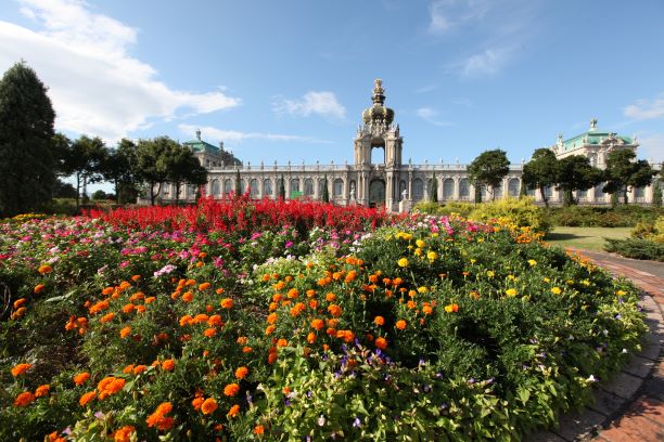 宮殿を囲むオレンジや赤やピンク色の花々が植えられているバロック庭園の様子。