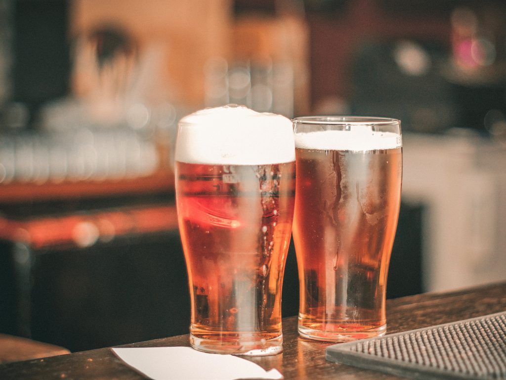 グラスに継がれた琥珀色のビールが２杯、並んでテーブルに置かれている様子。
