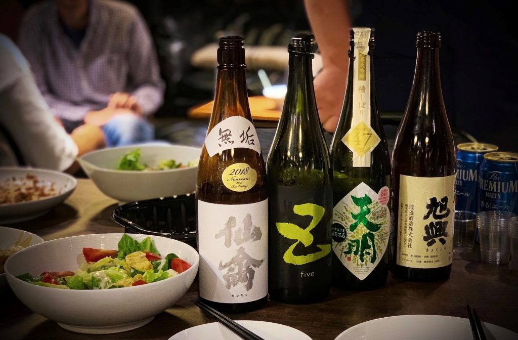 テーブルに4種の銘柄の日本酒と料理が並んでいる様子