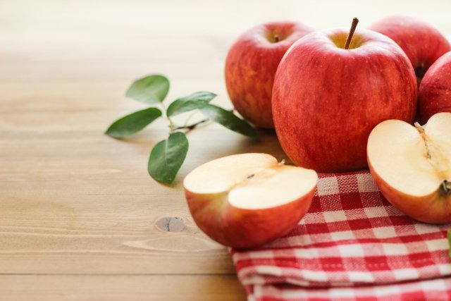丸々のリンゴとカットされているリンゴが布にのった様子。