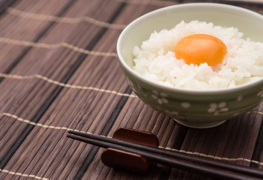 茶碗に入った卵かけご飯と木の箸