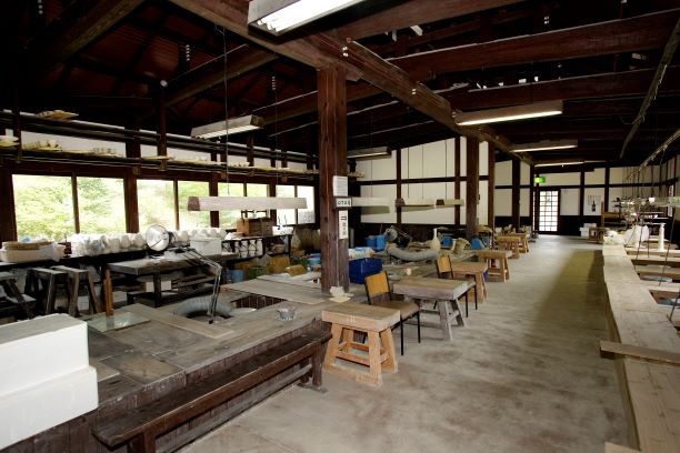 木椅子や台が並ぶ有田焼工房の様子。