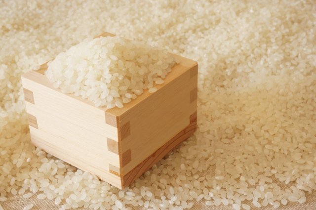 敷き詰められた米の上にある一升枡が置かれており、中には米が沢山入っている