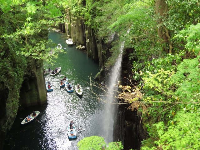 高千穂峡を貸しボートで観光している9艘のボートと滝。