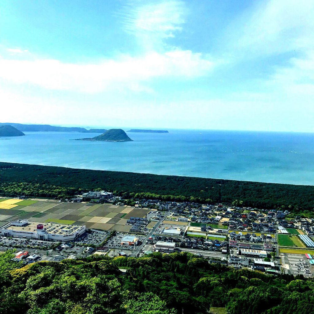 街の向こうには海が広がっており、「鏡山」が佇んでいる。